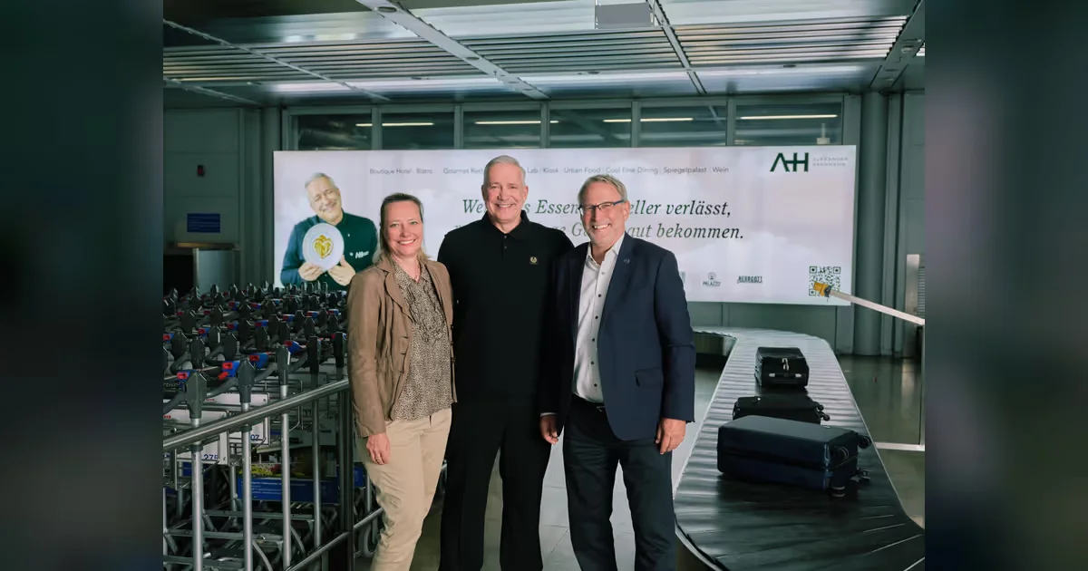 Sternekoch Alexander Herrmann mit Flughafengeschäftsführer und Marketing-Leiterin vor Werbetafel