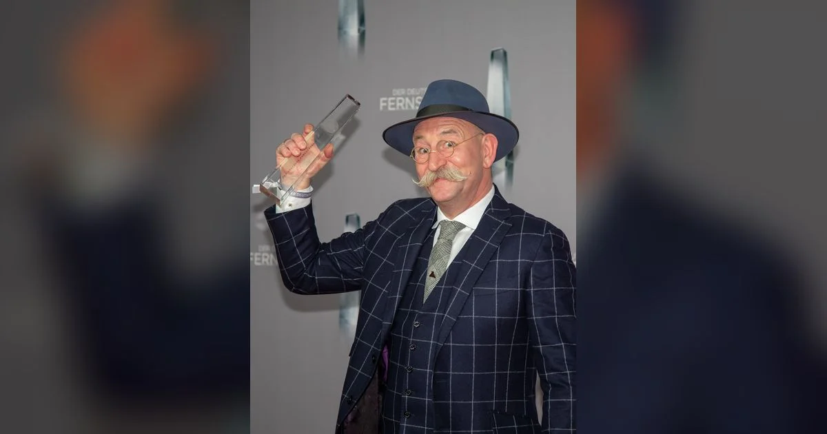 Horst Lichter mit Hut und gezwirbeltem Schnurrbart auf dem roten Teppich beim Deutschen Fernsehpreis
