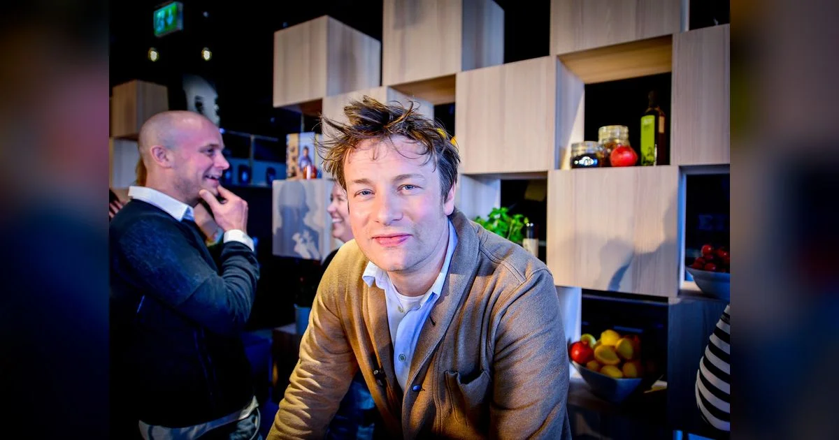 Jamie Oliver in beiger Strickjacke in einer Küchenkulisse