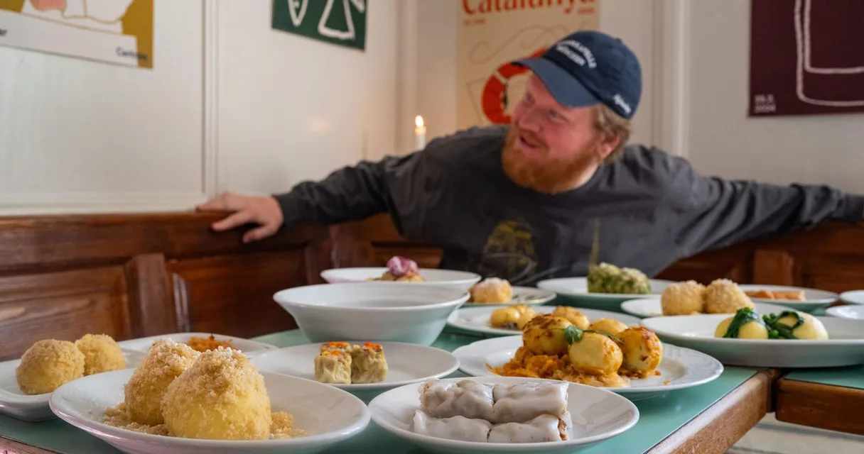 Lukas Mraz an einem Tisch voller Knödel und Mehlspeisen in Wien