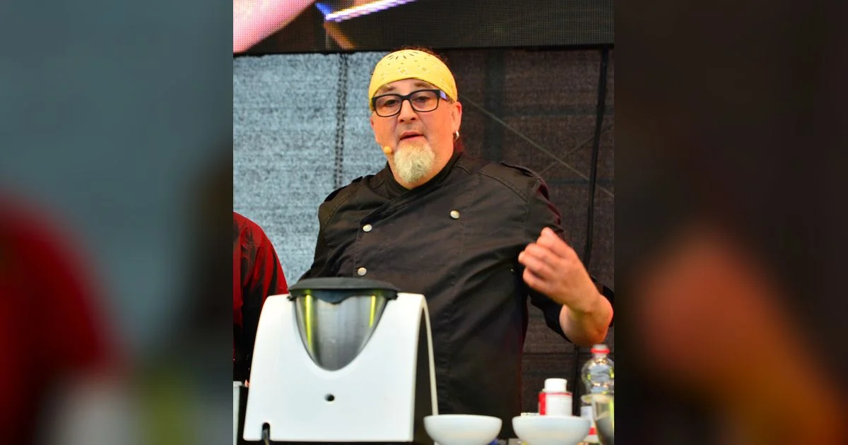 Stefan Marquard beim Kochen mit Bandana und Kochjacke auf einer Bühne