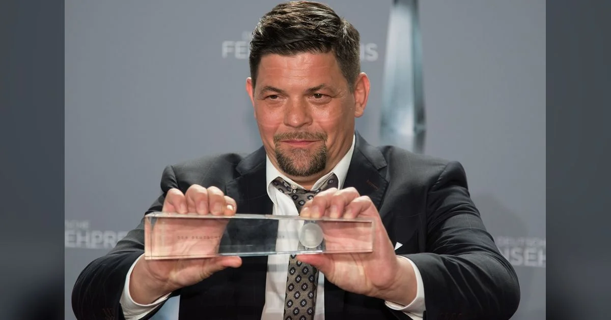 TV-Koch mit Trophäe des Deutschen Fernsehpreises auf dem roten Teppich